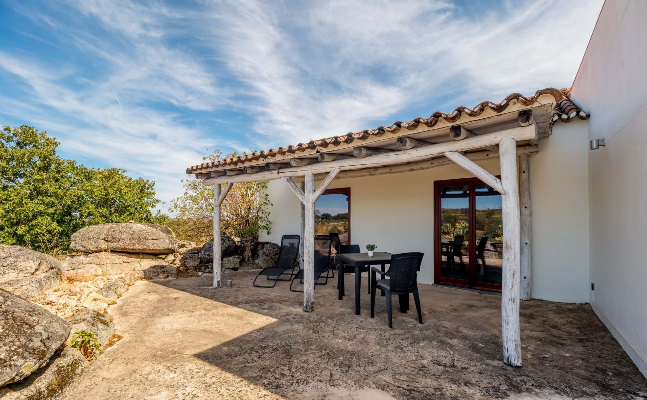 Überdachte Terrasse mit Holzpergola, Sitzgruppe und Blick ins Grüne