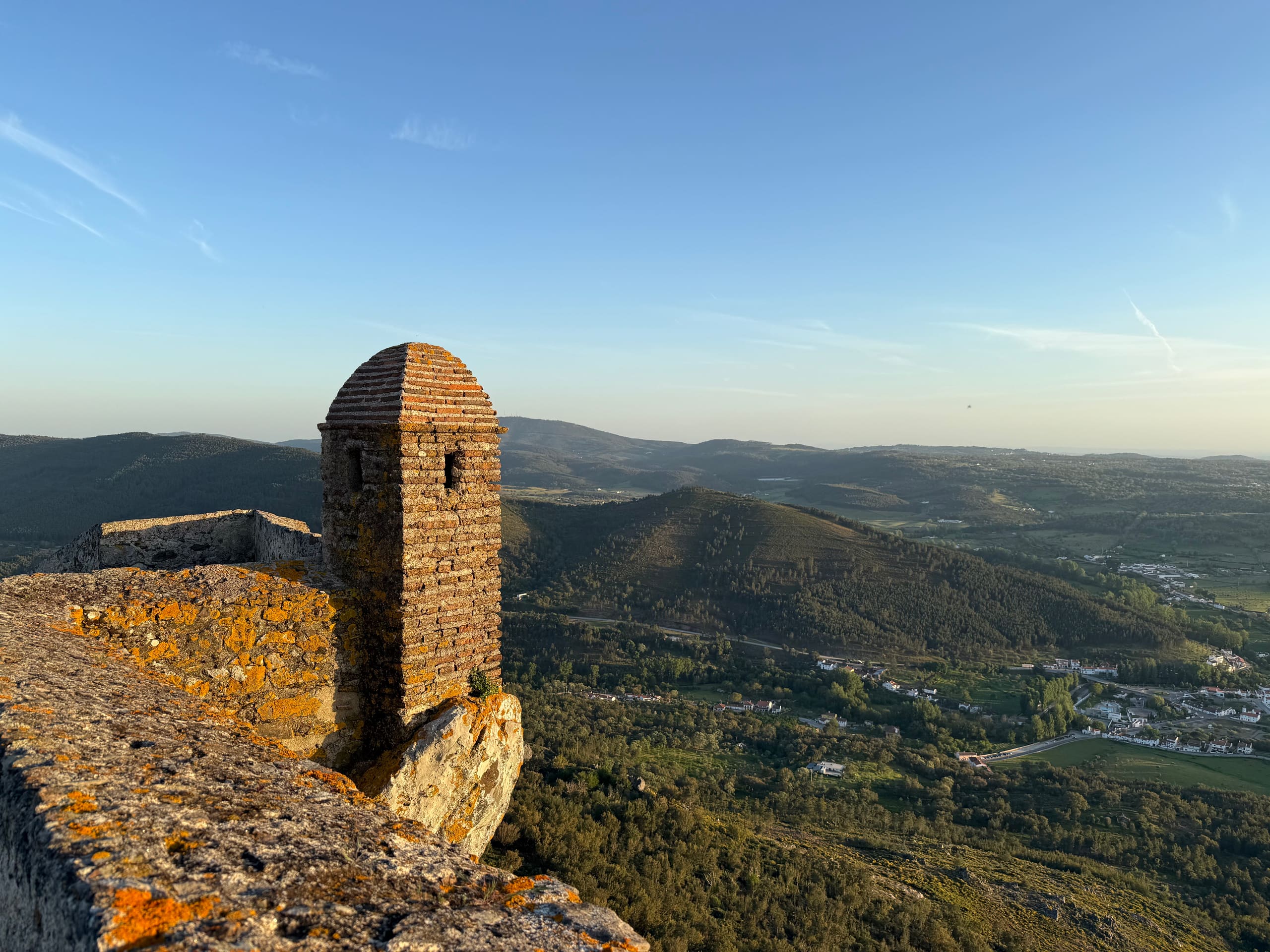 Alter Wachturm auf einer Burgmauer mit Weitblick über hügelige Landschaft